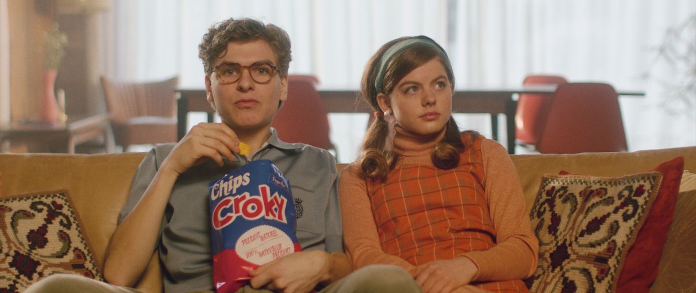 Couple jeune dans le canapé avec chips de Croky